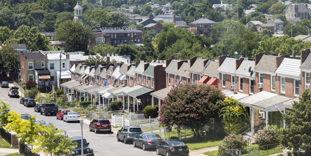 A row of houses lines a street in a Baltimore neighborhood.