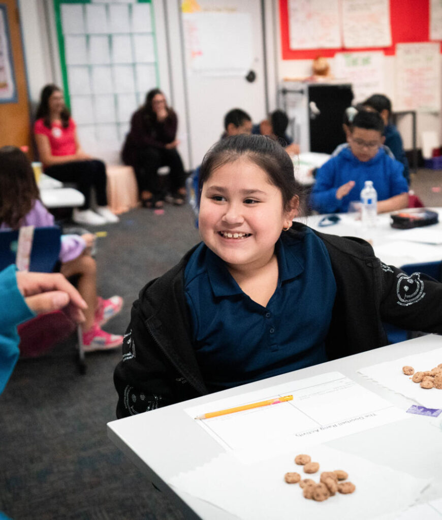Smiling student sits at a desk