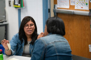 Two women sitting at a table engaged in discussion.